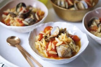Almejas con jitomate y harissa y pasta orzo con azafrán
