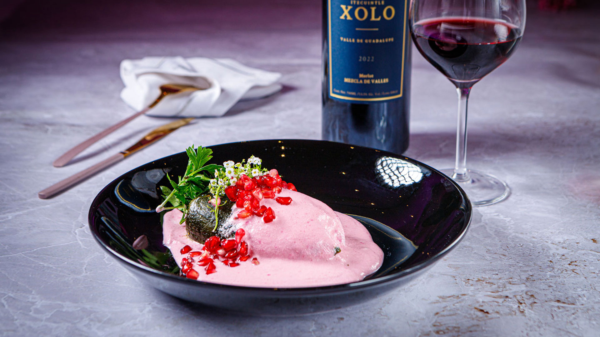 Chile en nogada rosa, reinterpretación de un clásico que brilló junto al merlot de Xolo Vino, vino de gran estructura y notas de frutos maduros.